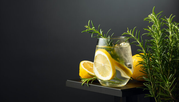 Refreshing drink with ice, lemon slices, and rosemary.