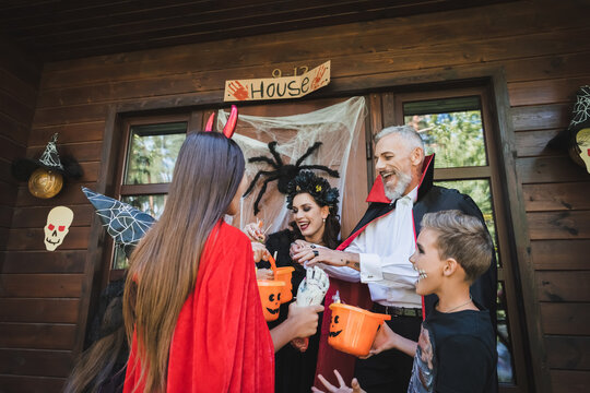 Family enjoys Halloween trick or treating at a charming decorated cottage