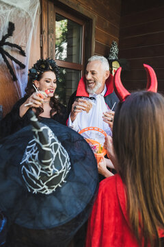 Family enjoys Halloween fun while trick-or-treating at a decorated cottage