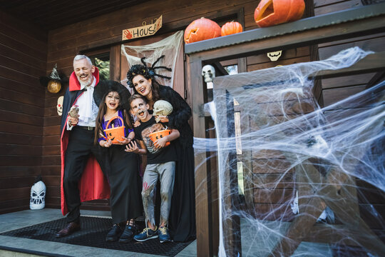 Happy family enjoying Halloween costumes and trick or treating fun together
