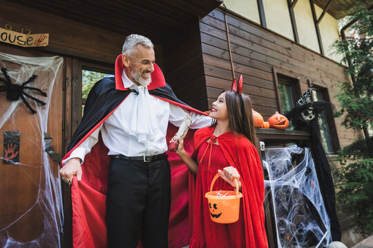 Mother and daughter delight in Halloween costumes during autumn fun outdoors