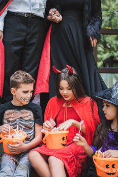 Family enjoys trick or treating fun with costumes at a decorated cottage