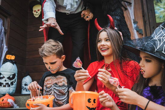 Happy family celebrates Halloween with costumes and treats at home