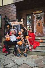 Fototapeta premium Happy family enjoys Halloween festivities near decorated cottage house