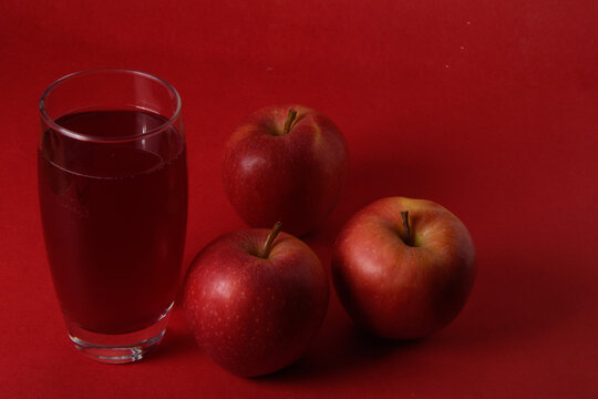 Vaso de zumo de manzana acompa&ntilde;ado de manzanas rojas frescas