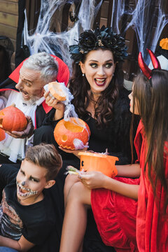 Joyful family revels in Halloween fun with costumes and treats outdoors