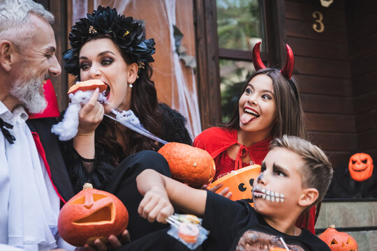 Family joy and laughter while trick or treating at a spooky Halloween house