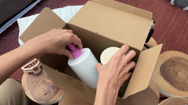 Manos de mujer abriendo caja de productos skincare