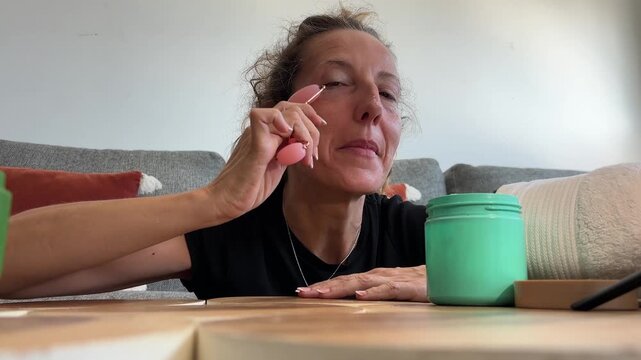 POV influencer usando rodillo facial para redes sociales
