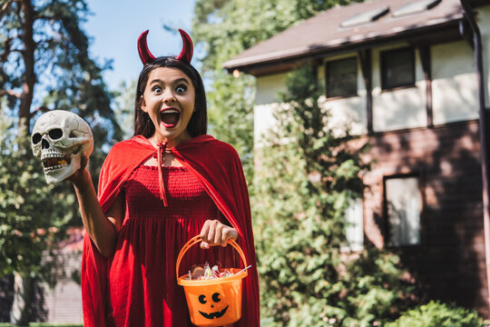 Exciting Halloween fun with a cute kid in costume near a decorated house