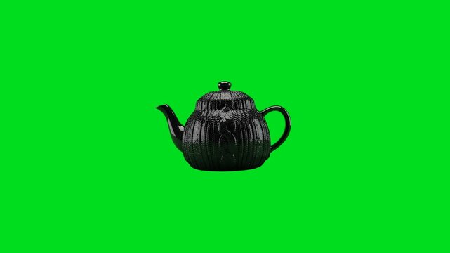 A black ceramic teapot with a textured cable knit pattern on green background