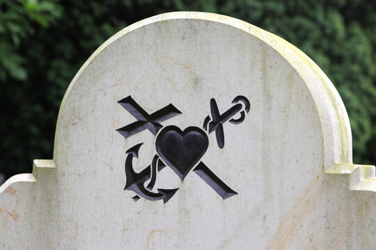 anker, herz und kreuz symbole auf einem grabstein
