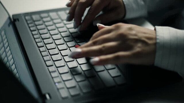 Female hands typing on laptop keyboard programming code in slow motion