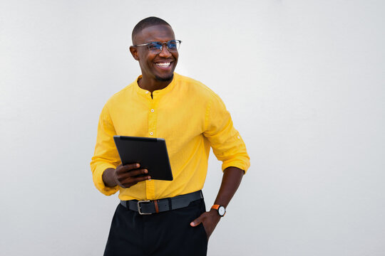 African american man, businessman holding tablet, looking aside, relaxed and confident in casual isolated studio business portrait. Startup founder browses content with smiling, engaged expression
