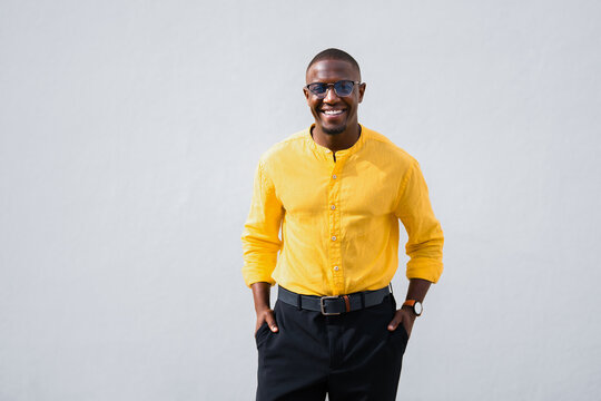 African american man, businessman poses with hands in pockets, confident smiling expression facing camera directly in casual isolated studio business portrait. Proud young manager for corporate