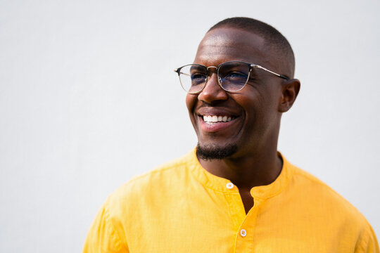 African american man, businessman looking aside, laughing and smiling candidly in close portrait at casual isolated studio background for business use. Happy young banker face closeup shot with