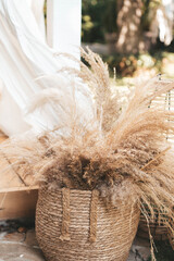 Dried pampas grass in a wicker basket, boho wedding decor © Oleksandra Dyka