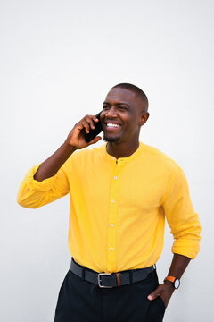 African american man, businessman talking on phone, cellphone business call, smiling in vertical casual isolated studio portrait. Young sales manager communication, discussing deal with client on