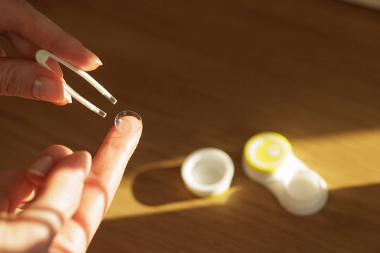 Contact lens taken from case with tweezers for vision correction