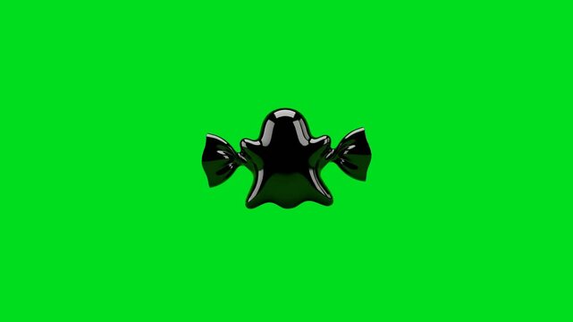 A shiny black ghost shaped candy isolated on a vibrant bright green background