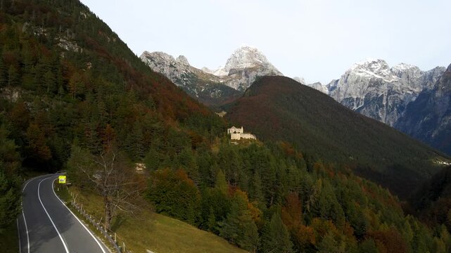 Drone ascending above Predil Pass with Fort Predil and snow-capped peaks in Background, Slovenia