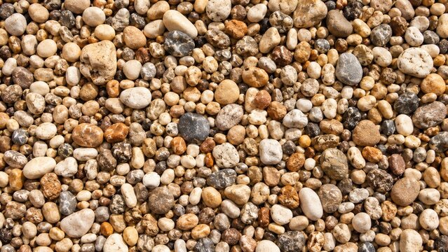 Close-up texture of mixed small pebbles and gravel in warm earthy tones