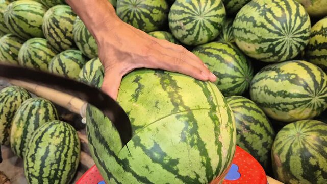 Vendor Cutting Watermelon With Knife For Quality Inspection Close Up Shot