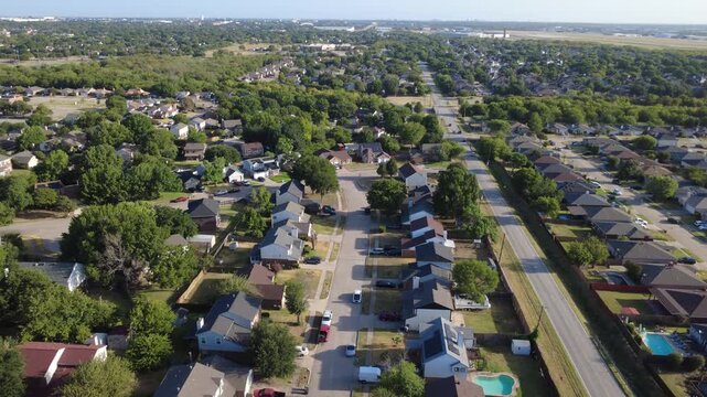 Sparkling blue swimming pools brighten backyard lots along Nicole Court neighborhood tract. Single family brick houses face long residential access avenues, driveways, Arlington, Texas