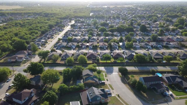 Gleaming rooftop solar panels distinguish residential properties along Southeast Parkway. Fenced yards border quiet subdivision streets, green tree lines, lush lawns, Arlington, Texas