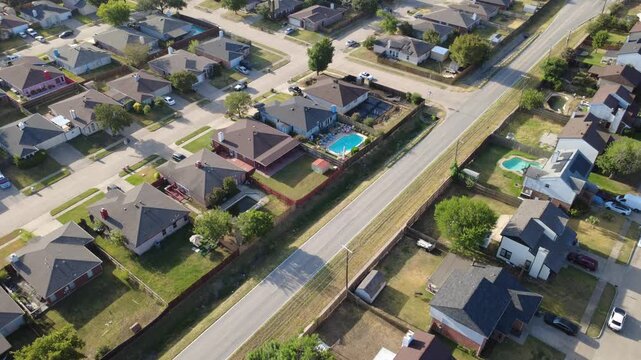 Turquoise swimming pools highlight private backyards bordering Southeast Parkway corridor. Single family brick houses face tree lined residential streets, driveways, Arlington, Texas