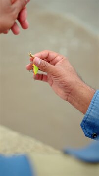Close-up Senior man preparing fishing gear by the seaside. Retirement lifestyle active aging. Healthy longevity, outdoor recreation, peaceful leisure. Life insurance planning for a secure retirement.
