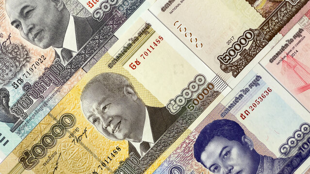 A variety of Cambodian banknotes of various denominations featuring portraits of members of the royal family and traditional Khmer motifs. The national currency of Cambodia, the riel.