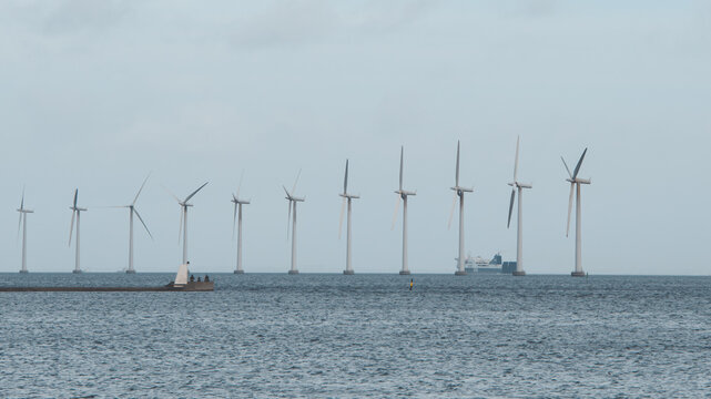 Offshore Wind Turbines and Cargo Ship in Misty Coastal Waters