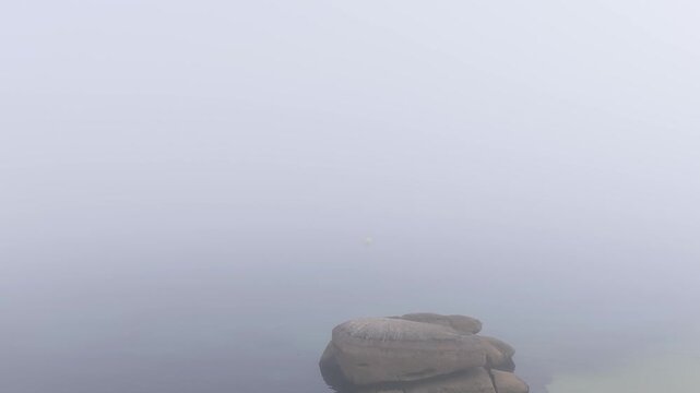 A time-lapse sequence showing thick coastal fog gradually clearing to reveal a bright blue sky over Praia das Pipas, a beach in O Grove, Galicia, Spain.