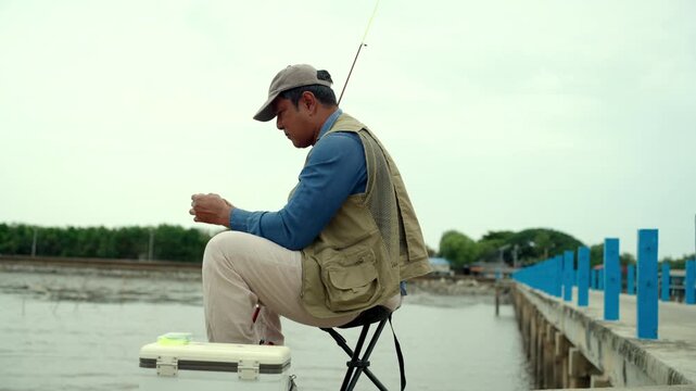 Senior man preparing fishing gear by the seaside. Retirement lifestyle active aging. Healthy longevity, outdoor recreation, peaceful leisure. Life insurance planning for a secure retirement.
