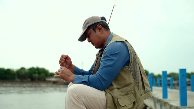Senior man preparing fishing gear by the seaside. Retirement lifestyle active aging. Healthy longevity, outdoor recreation, peaceful leisure. Life insurance planning for a secure retirement.
