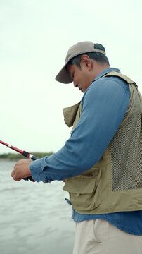 Happy senior man fishing by the sea during retirement. Active aging, outdoor leisure healthy longevity. Independence, retirement lifestyle, life insurance. Financial security for a fulfilling future.
