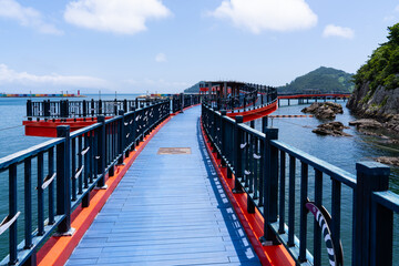 Fototapeta premium Elevated View of Winding Blue Coastal Pier Bridge with Red Edge Trim