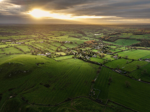 Stunning aerial flying drone landscape images of Thorpe Cloud in Peak Disdtrict during beautiful Autumn sunrise with amazing light
