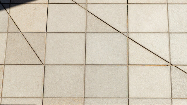 Abstract light beige square floor tiles with diagonal geometric design pattern
