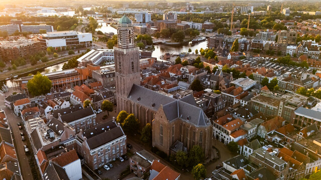Aerial view of the Grote of Sint-Michaelskerk surrounded by historic rooftops, canals, and urban architecture during the golden hour in Zwolle, Overijssel, Netherlands.