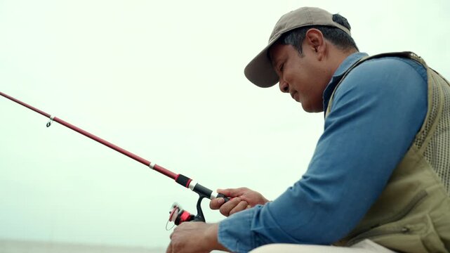 Happy senior man fishing by the sea during retirement. Active aging, outdoor leisure healthy longevity. Independence, retirement lifestyle, life insurance. Financial security for a fulfilling future.
