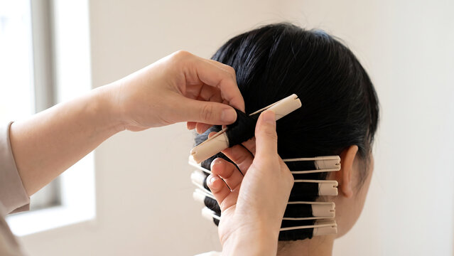 美容室でパーマロッドを髪に巻く美容師の手元