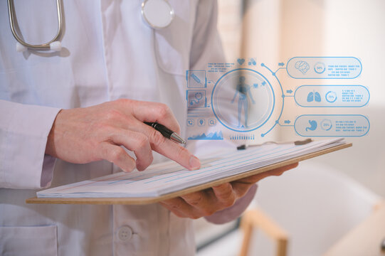Male doctor wearing white cloth using stethoscope tablet and computer working diagram analysing patient diagnosis data with virtual heart icon in medicine and healthcare concept