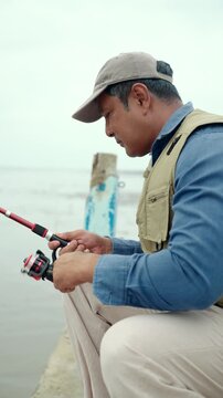 Happy senior man fishing by the sea during retirement. Active aging, outdoor leisure healthy longevity. Independence, retirement lifestyle, life insurance. Financial security for a fulfilling future.

