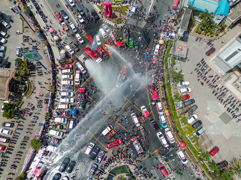 Aerial view of fire trucks spraying water over a crowded intersection during an independence day celebration in Kota Samarinda, Kalimantan Timur, Indonesia.