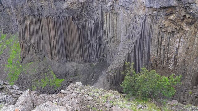 Rugged volcanic landscape with river flowing through rocky canyon and natural cave formations in Iceland. Dramatic scene of basalt rocks