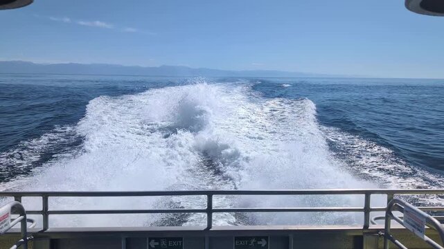 Large wake behind a fast boat crossing the ocean, high speed driving