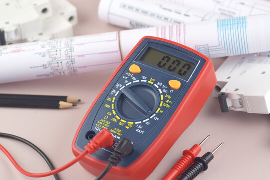 The digital multimeter electrical engineering drawings, circuit breaker and pencils.