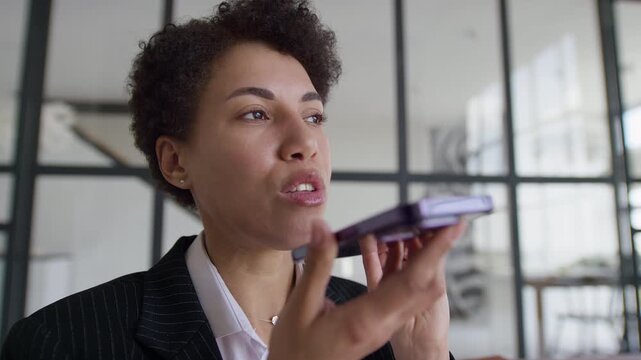 Professional Woman Recording Voice Message on Smartphone